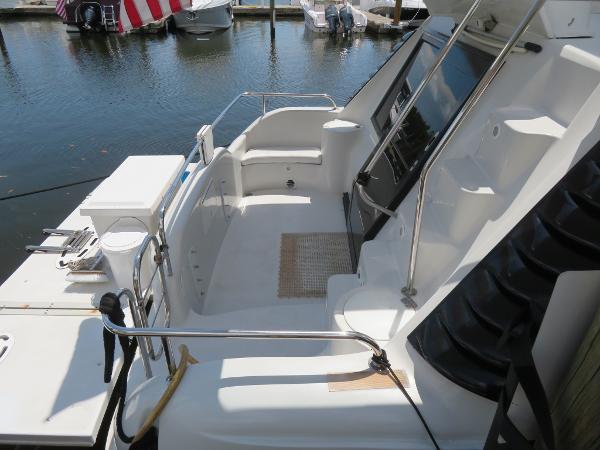 Slide: The Image of Bluewater 5800 yacht, 2000 model, docked with a clean, spacious deck and seating area. - 25