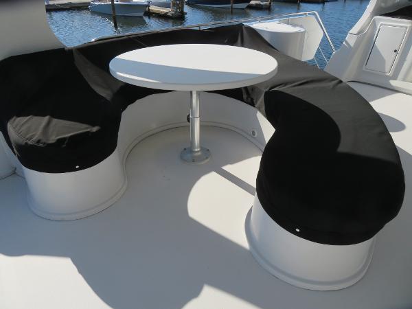 Slide: The Image of Curved seating area with table on a 2000 Bluewater 5800 yacht. - 29