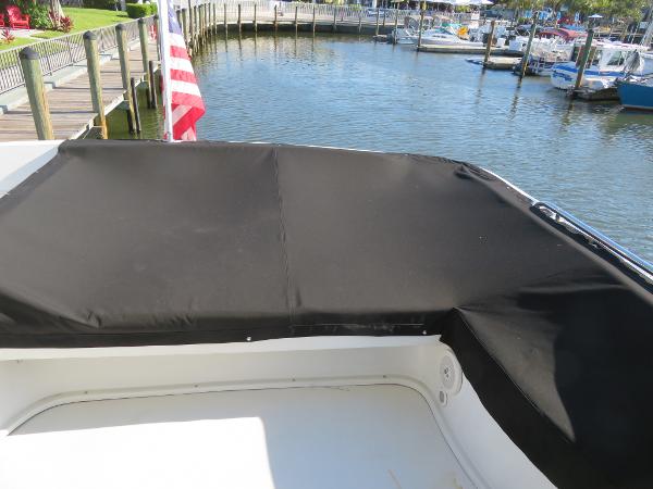 Slide: The Image of Bluewater 5800 (2000) yacht with black cover docked at marina. - 31