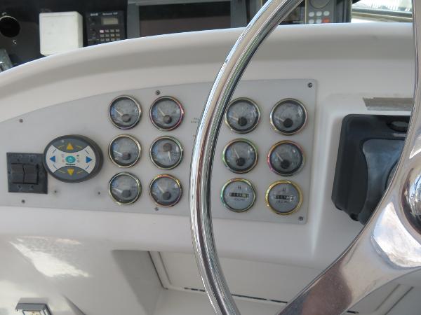 Slide: The Image of Control panel of a 2000 Bluewater 5800 boat with gauges and steering wheel. - 46
