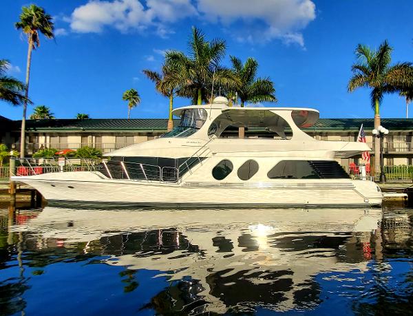 Slide: The Image of Luxury Bluewater 5800 yacht docked, palm trees and blue sky in the background. - 7