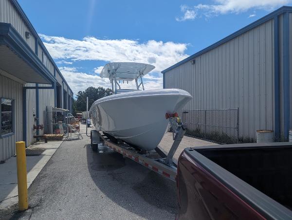 Slide: The Image of 2024 Bluewater Sportfishing 2850 boat on a trailer outside a warehouse. - 0
