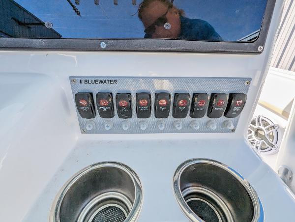 Slide: The Image of Control panel of 2024 Bluewater Sportfishing 2850 boat with switches and cup holders. - 27