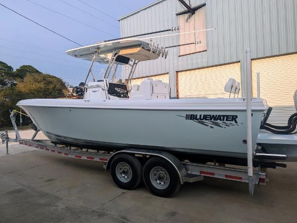 Slide: The Image of 2024 Bluewater Sportfishing 2850 boat on a trailer outside a warehouse. - 31