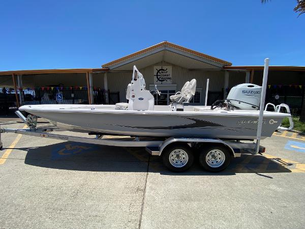 Slide: The Image of 2023 Blue Wave 2200 STL boat on a trailer outside a building. - 0