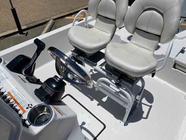 Slide: The Image of 2023 Blue Wave 2200 STL boat interior with dual captain's chairs and steering console. - 17