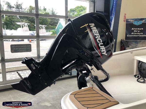 Slide: The Image of 2023 Boston Whaler 130 Super Sport with Mercury outboard motor in showroom. - 2