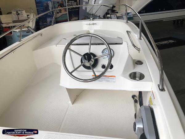 Slide: The Image of 2023 Boston Whaler 130 Super Sport boat interior with steering wheel and control panel. - 4