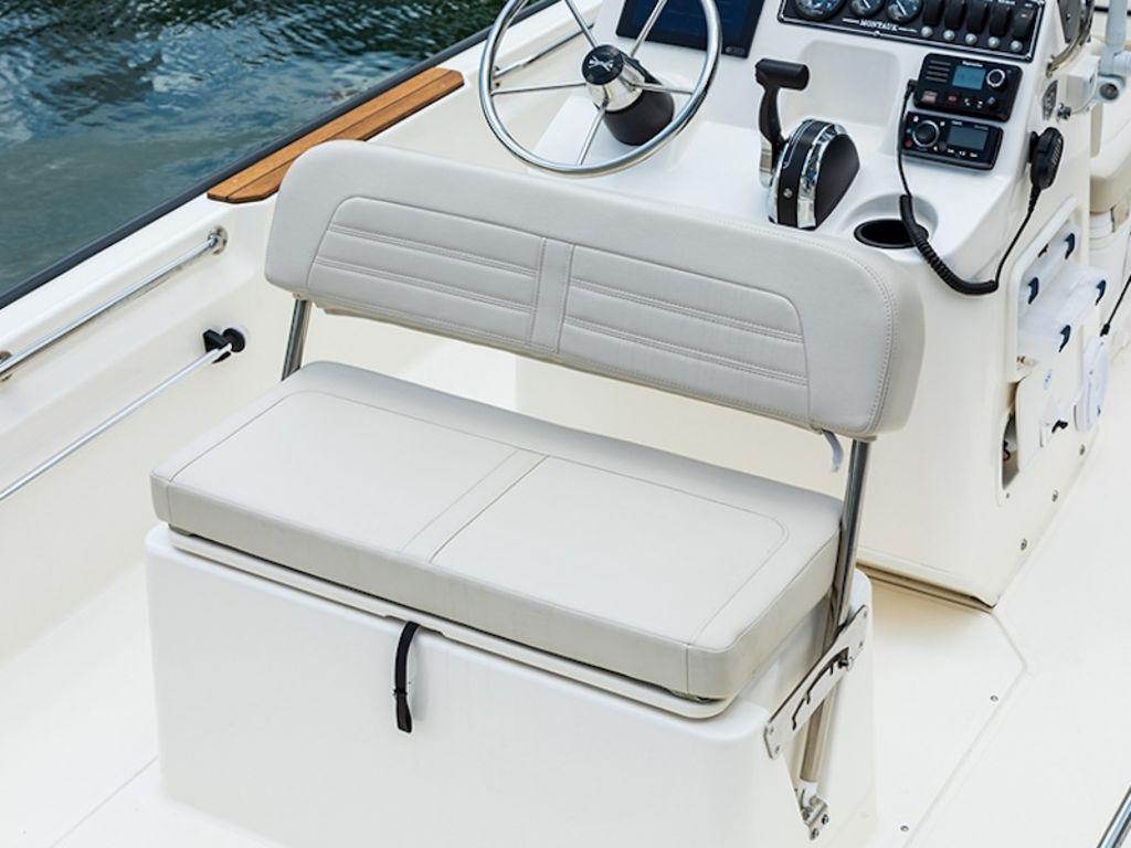 Slide: The Image of 2024 Boston Whaler 170 Montauk boat interior with steering wheel and cushioned seating. - 8