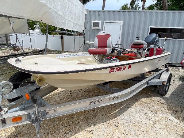 Slide: The Image of 1976 Boston Whaler 150 Sport boat on trailer, parked outdoors near a storage unit. - 1