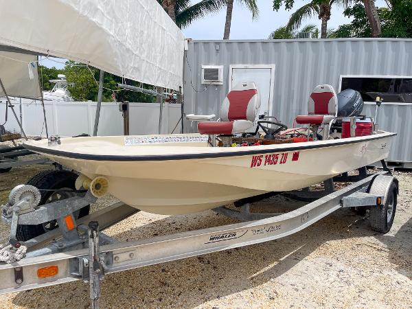 Slide: The Image of 1976 Boston Whaler 150 Sport boat on trailer with red seats. - 13