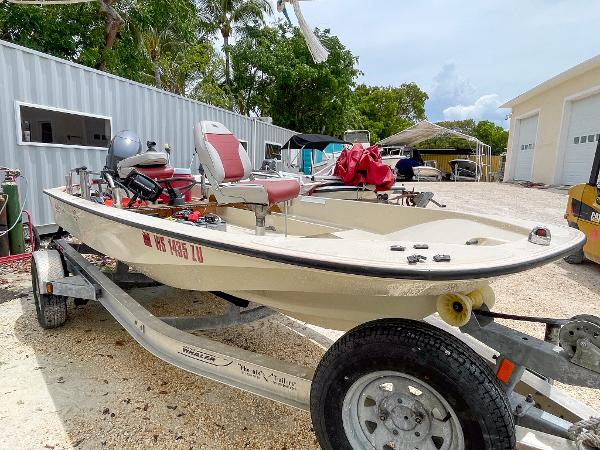 Slide: The Image of 1976 Boston Whaler 150 Sport boat on trailer, parked outdoors near storage units. - 3