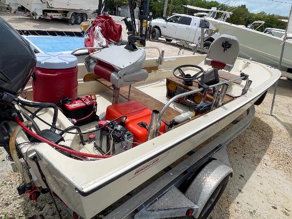 Slide: The Image of 1976 Boston Whaler 150 Sport boat on trailer, equipped with outboard motor and various gear. - 7
