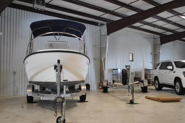 Slide: The Image of 2001 Boston Whaler 16 Dauntless boat in a storage facility. - 16