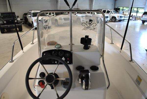 Slide: The Image of 2001 Boston Whaler 16 Dauntless boat console with steering wheel and controls in a garage. - 9