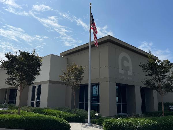 Slide: The Image of Modern office building with American flag and landscaped greenery. - 1
