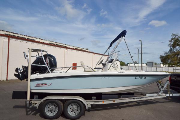 Slide: The Image of 2019 Boston Whaler 180 Dauntless boat on a trailer in a parking lot. - 0