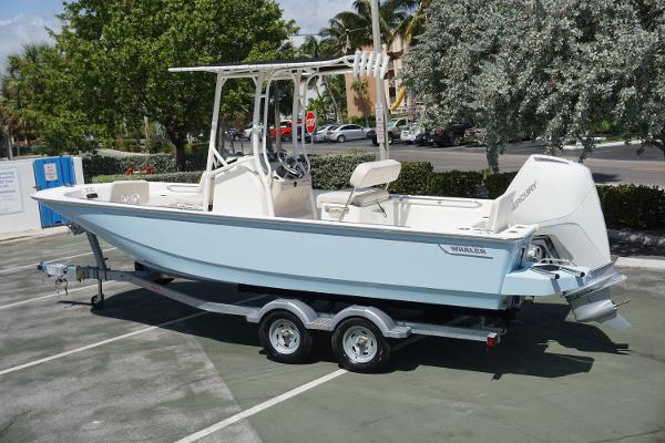 Slide: The Image of 2024 Boston Whaler 210 Montauk boat on a trailer in a parking lot. - 1