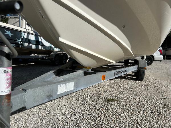 Slide: The Image of 2007 Boston Whaler 220 Dauntless boat on trailer, parked on gravel. - 12