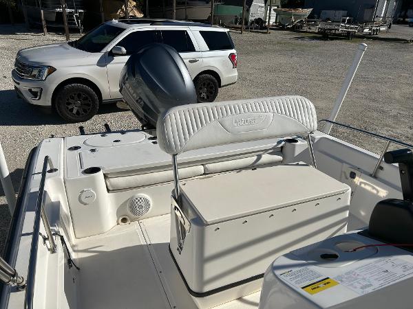 Slide: The Image of 2007 Boston Whaler 220 Dauntless boat interior with seating and storage, parked near SUV. - 15