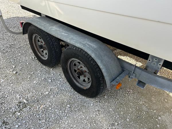 Slide: The Image of Trailer wheels for 2007 Boston Whaler 220 Dauntless on gravel surface. - 4