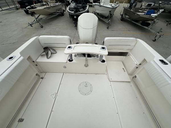 Slide: The Image of 1998 Boston Whaler 23 Conquest boat interior, spacious deck with seating and storage. - 24