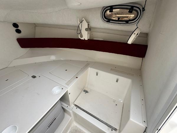 Slide: The Image of 1998 Boston Whaler 23 Conquest cabin interior with storage compartments and porthole. - 29