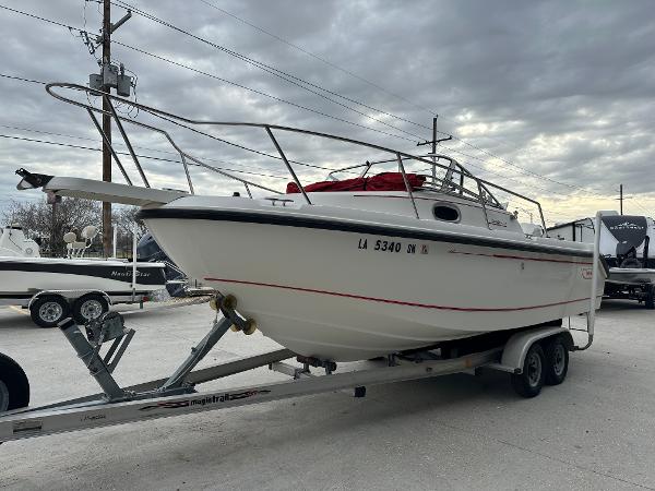 Slide: The Image of 1998 Boston Whaler 23 Conquest boat on a trailer under cloudy skies. - 5