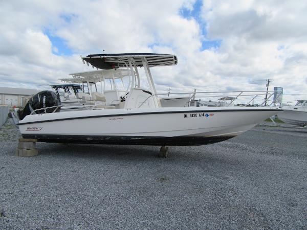 Slide: The Image of 2019 Boston Whaler 240 Dauntless boat on gravel lot under cloudy sky. - 0