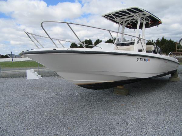 Slide: The Image of 2019 Boston Whaler 240 Dauntless boat on gravel lot under cloudy sky. - 2