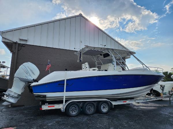 Slide: The Image of 2008 Boston Whaler 320 Outrage Cuddy Cabin on trailer, blue and white hull, parked outdoors. - 0