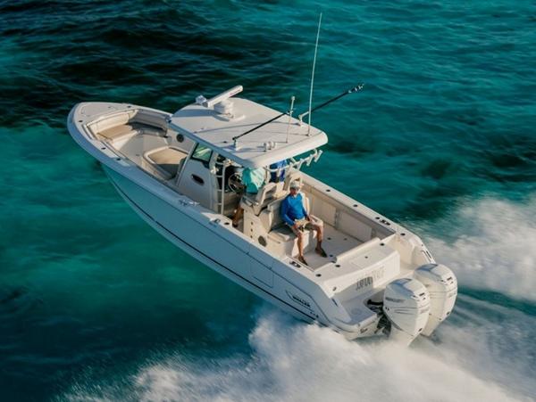 Slide: The Image of 2024 Boston Whaler 330 Outrage cruising on clear blue water. - 37