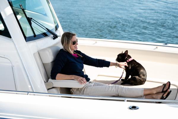 Slide: The Image of Woman relaxing with dog on a 2024 Boston Whaler 330 Outrage boat. - 41