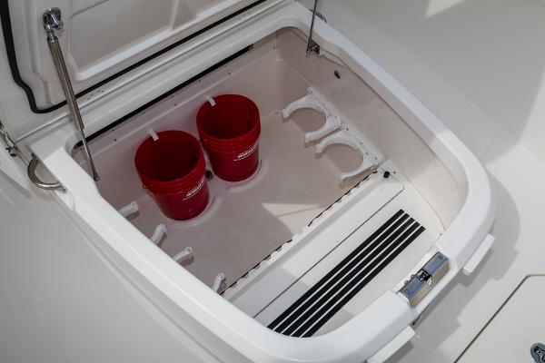 Slide: The Image of Storage compartment of 2024 Boston Whaler 330 Outrage with red buckets. - 42