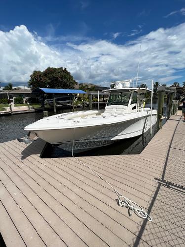 Slide: The Image of 2013 Boston Whaler 370 Outrage docked at marina under blue sky. - 4