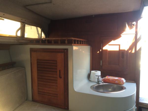 Slide: The Image of 1987 Boston Whaler Cuddy Tower interior with sink, wooden cabinet, and seating area. - 7