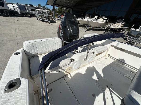 Slide: The Image of 2000 Boston Whaler Outrage 18 boat interior with seating and motor, parked outdoors. - 7