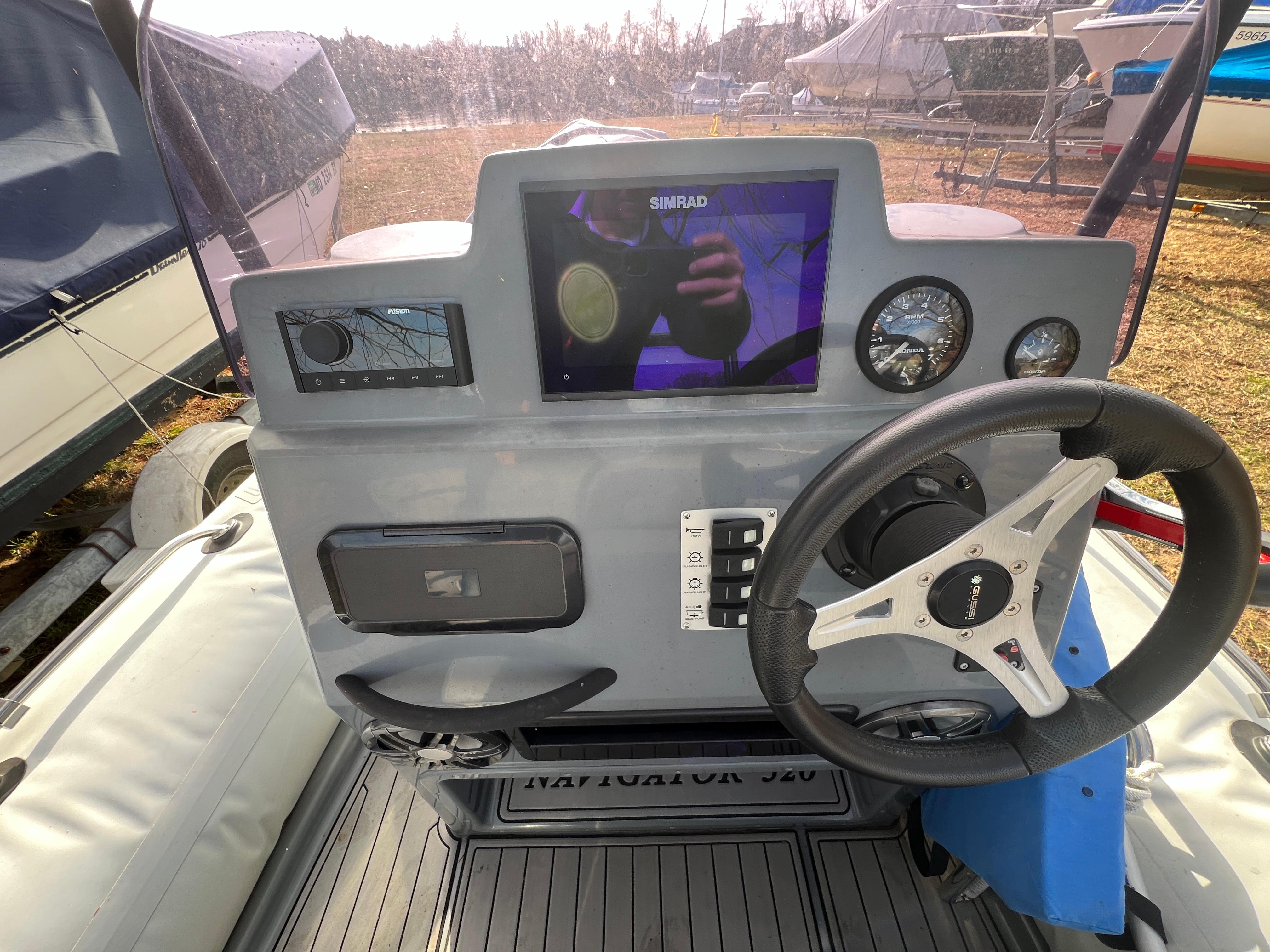 Slide: The Image of 2021 Brig Inflatables Navigator 520 dashboard with steering wheel, gauges, and Simrad display. - 2