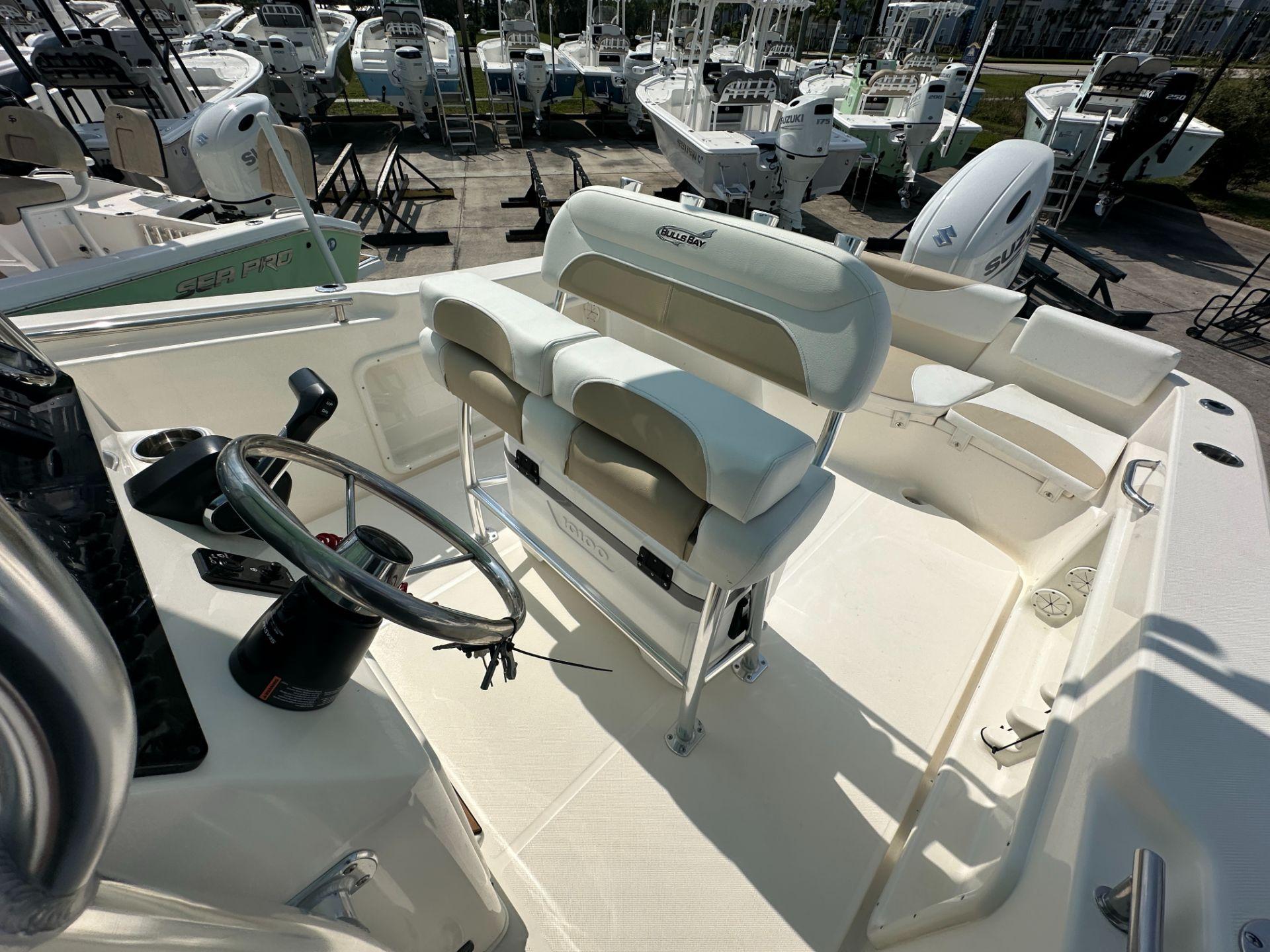 Slide: The Image of 2024 Bulls Bay 230CC center console boat interior with steering wheel and seating. - 7