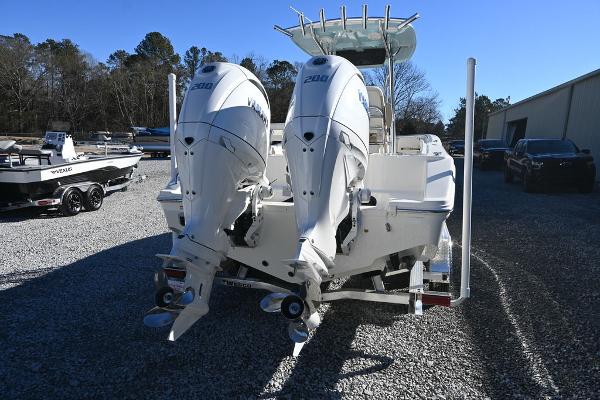 Slide: The Image of 2025 Bulls Bay 255CC boat with dual outboard engines in a gravel lot. - 3