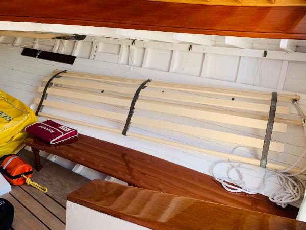 Slide: The Image of Interior of a 1914 Buzzards Bay 25 sailboat with wooden benches and nautical equipment. - 6