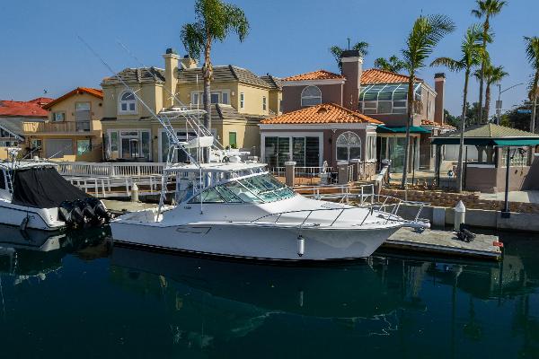 Slide: The Image of 2013 Cabo 36 Express yacht docked near waterfront homes. - 0