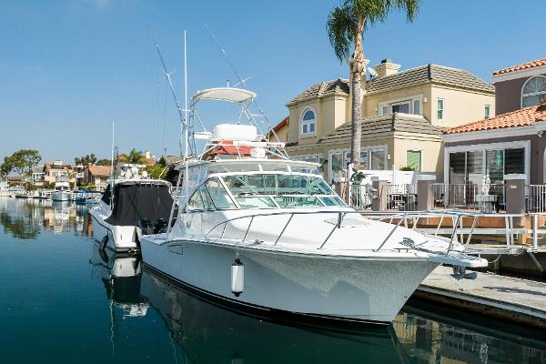 Slide: The Image of 2013 Cabo 36 Express yacht docked in a marina with waterfront homes. - 1