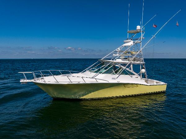 Slide: The Image of 2005 Cabo 40 Express yacht on open water under clear blue sky. - 0