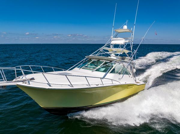Slide: The Image of 2005 Cabo 40 Express yacht cruising on open sea under clear blue sky. - 1