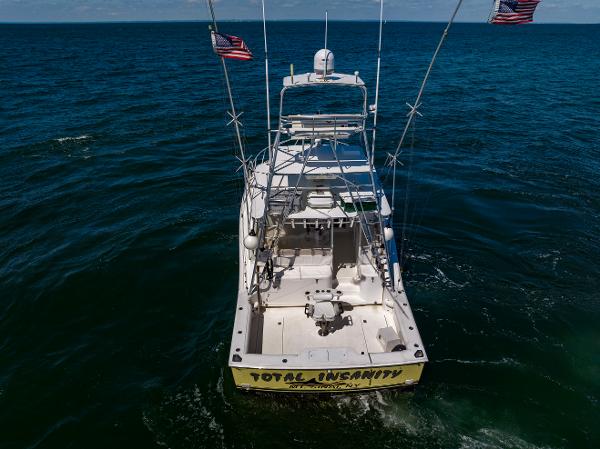 Slide: The Image of 2005 Cabo 40 Express boat on open sea, rear view with fishing equipment. - 10