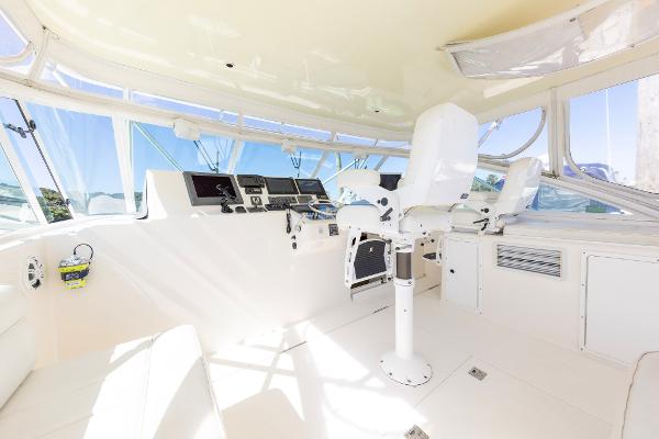 Slide: The Image of 2005 Cabo 40 Express yacht helm with modern controls and white seating. - 14
