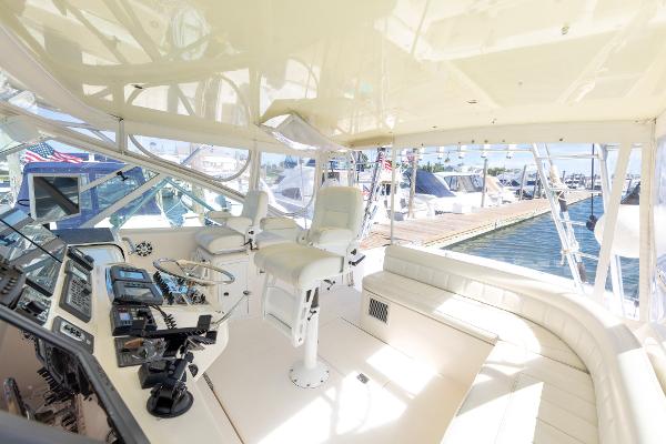 Slide: The Image of 2005 Cabo 40 Express yacht interior with helm, seating, and marina view. - 17