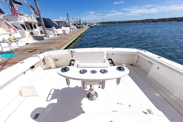 Slide: The Image of 2005 Cabo 40 Express boat docked, featuring spacious deck and fishing rod holders. - 20