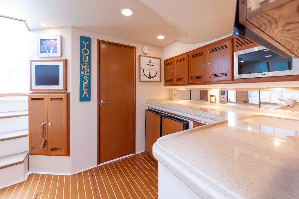 Slide: The Image of Interior of 2005 Cabo 40 Express yacht with modern kitchen and wooden accents. - 25
